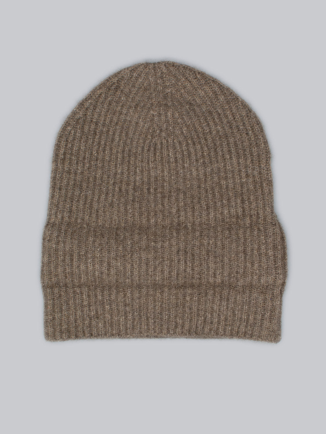 The Everest Cashmere Beanie by ID Menswear, shown in brown ribbed knit and laid flat on a light gray background, highlights its versatile style and cozy comfort.