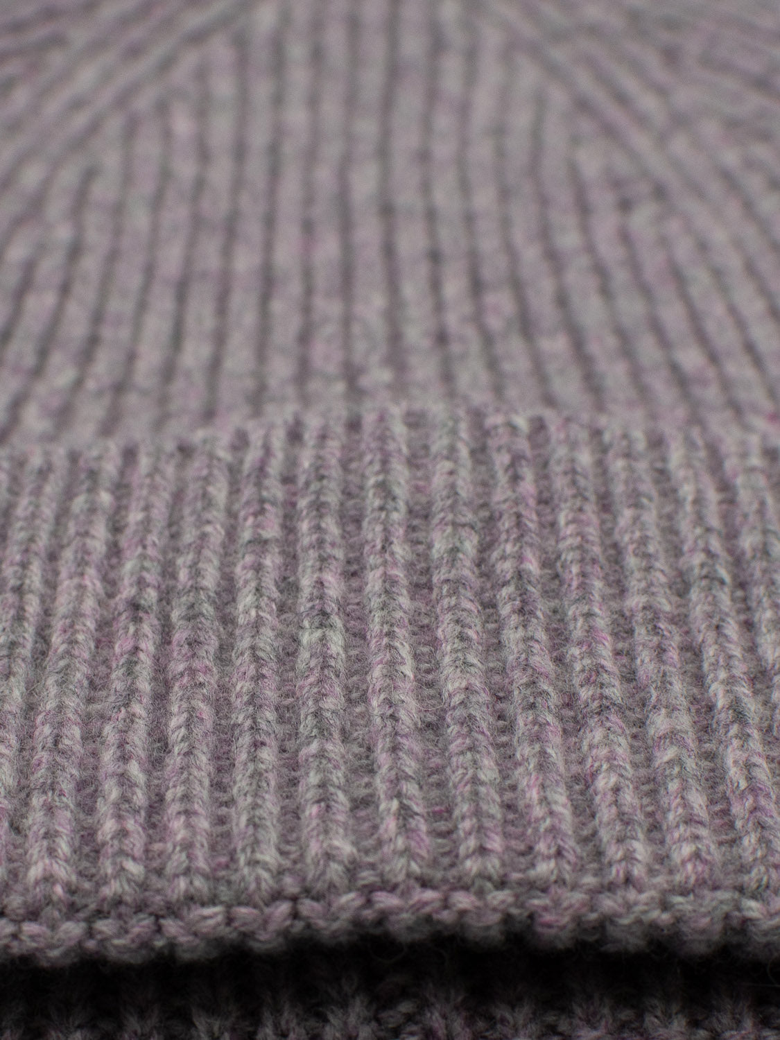 A close-up of ID Menswears Fuji Merino Wool Beanie showcases its gray ribbed knit fabric. The detailed stitching and warm, cozy appearance make it perfect for winter wear.