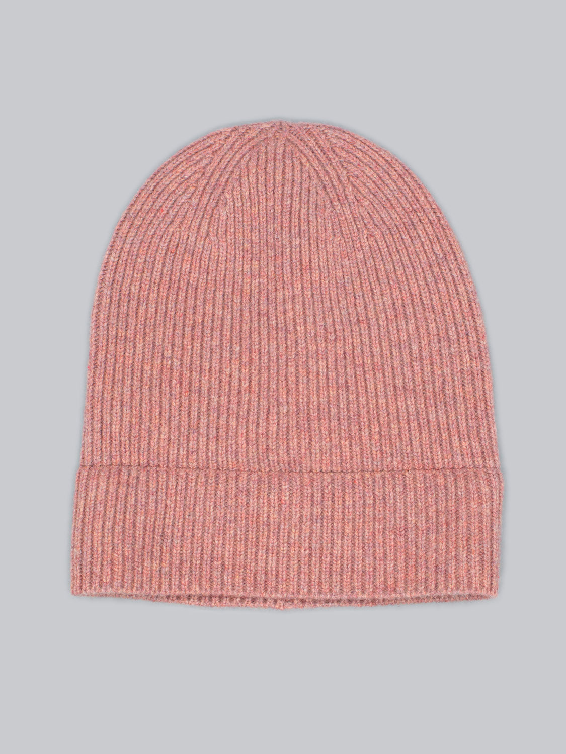 A Fuji Merino Wool Beanie from ID Menswear, in pink with a ribbed pattern and folded brim, is set against a light gray background, ideal for winter warmth.