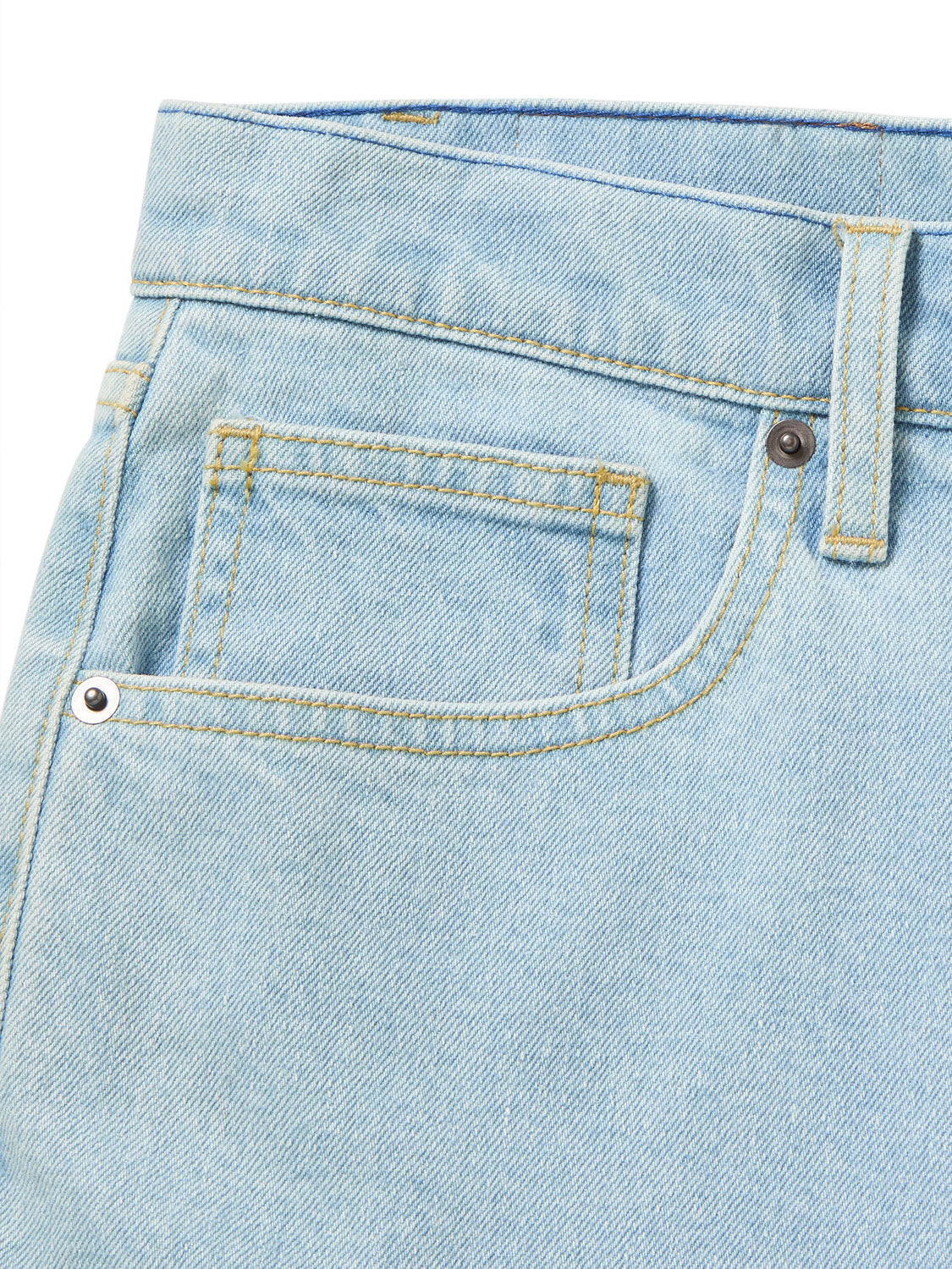 Close-up of the front pocket on Katins George 64 Short in light blue denim with a classic wash, featuring gold stitching and metal rivets. The textured fabric suggests standard jean material and a relaxed fit typical of these shorts.