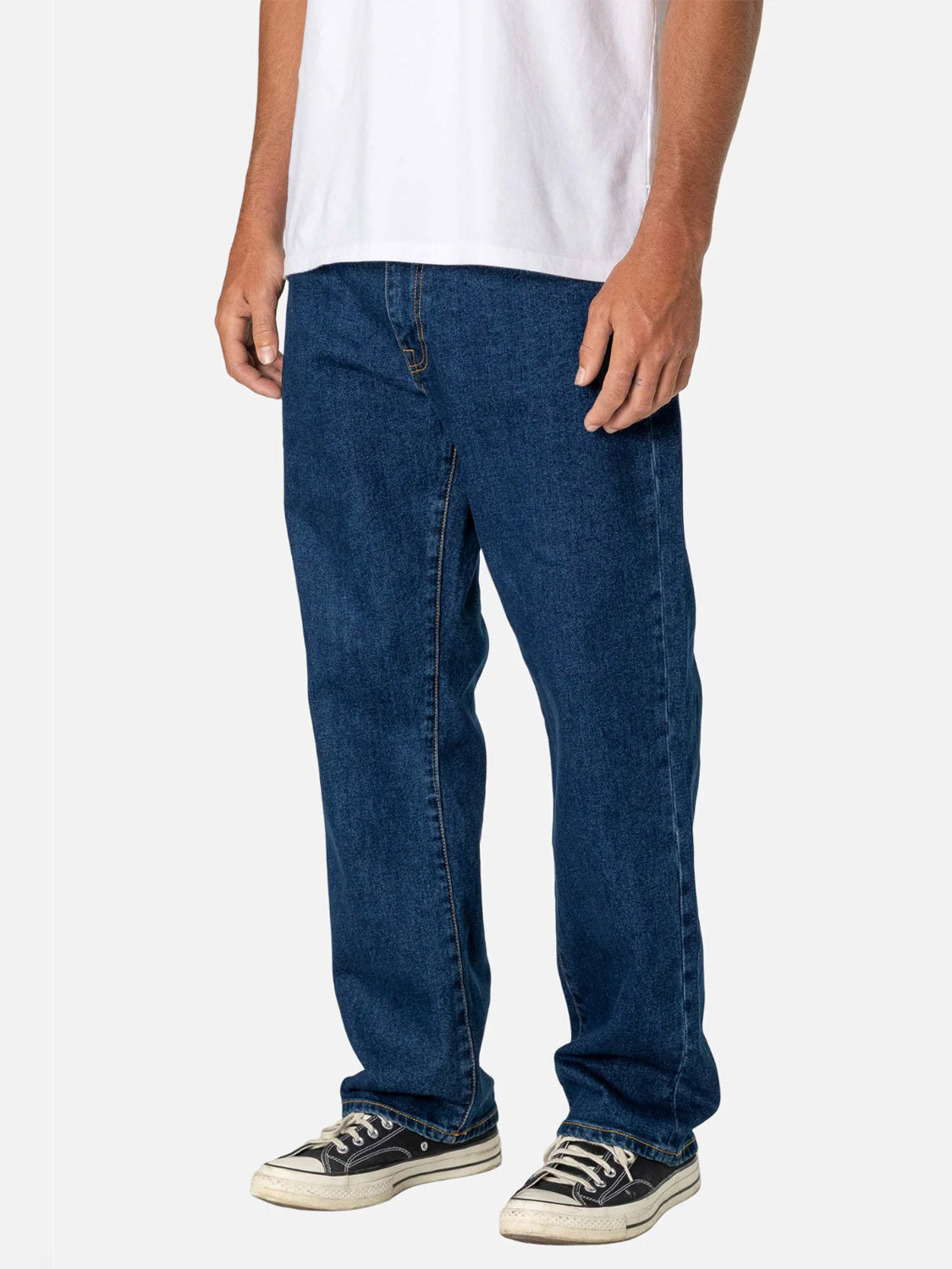 A person stands against a plain background, showcasing the laid-back style of the Katin George 64 Relaxed Pants, paired with a white T-shirt and black and white sneakers, with focus on the pants’ relaxed fit and 5-pocket design.