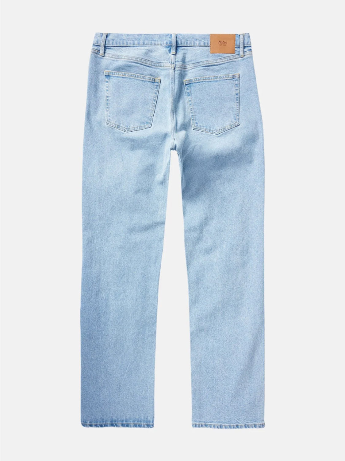 The Katin George 64 Relaxed Pants are light blue 5-pocket jeans with two back pockets, belt loops, and a brown leather patch on the waistband. They feature a simple, classic look and a comfortable straight-leg fit.