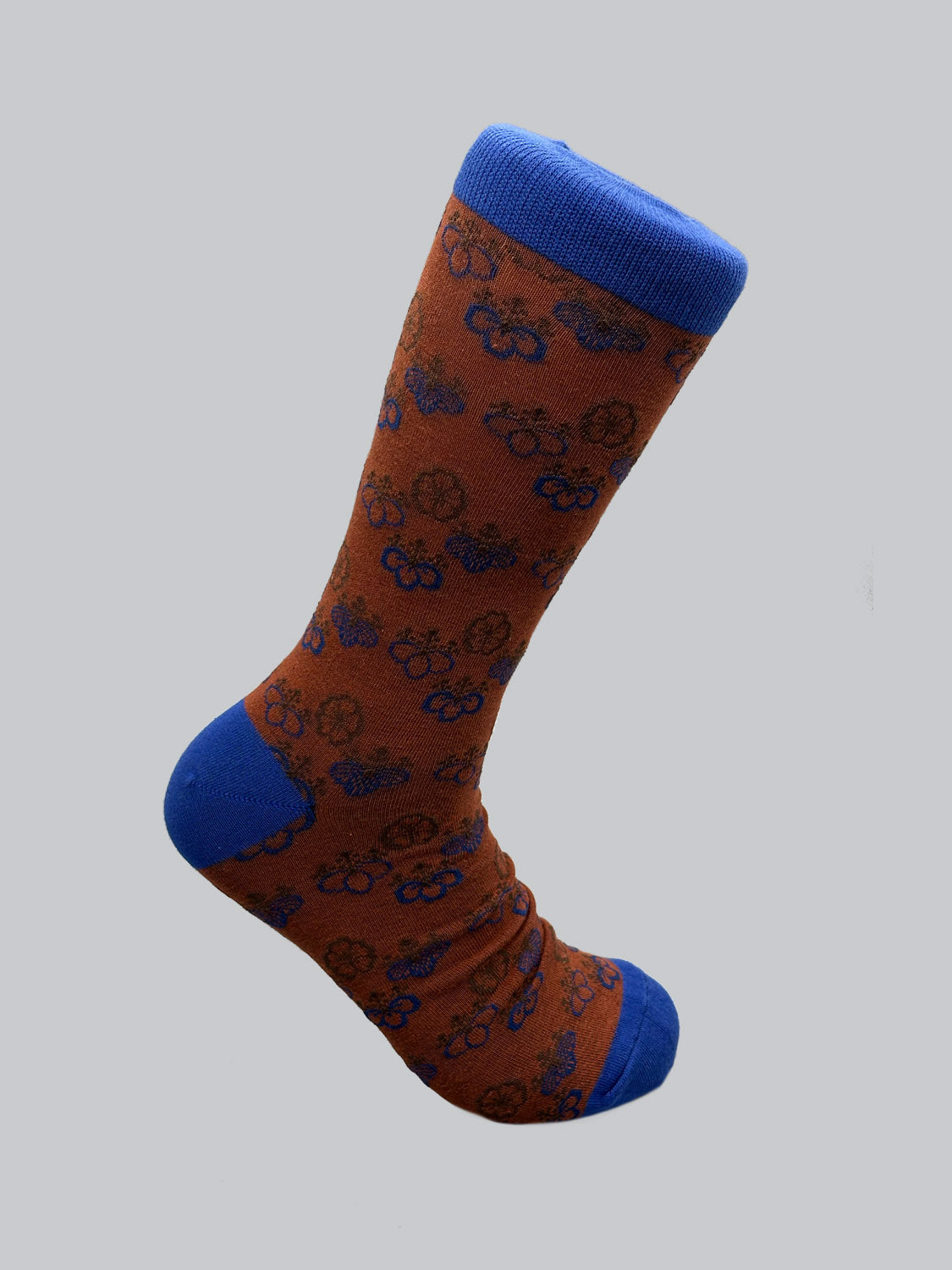 The Giri Graphic Socks by ID Menswear feature a soft, luxurious feel with a charming navy blue and brown bicycle design. This stylish look is complemented by blue toe, heel, and cuff areas, while a Japanese pattern adds flair against the solid light gray background.