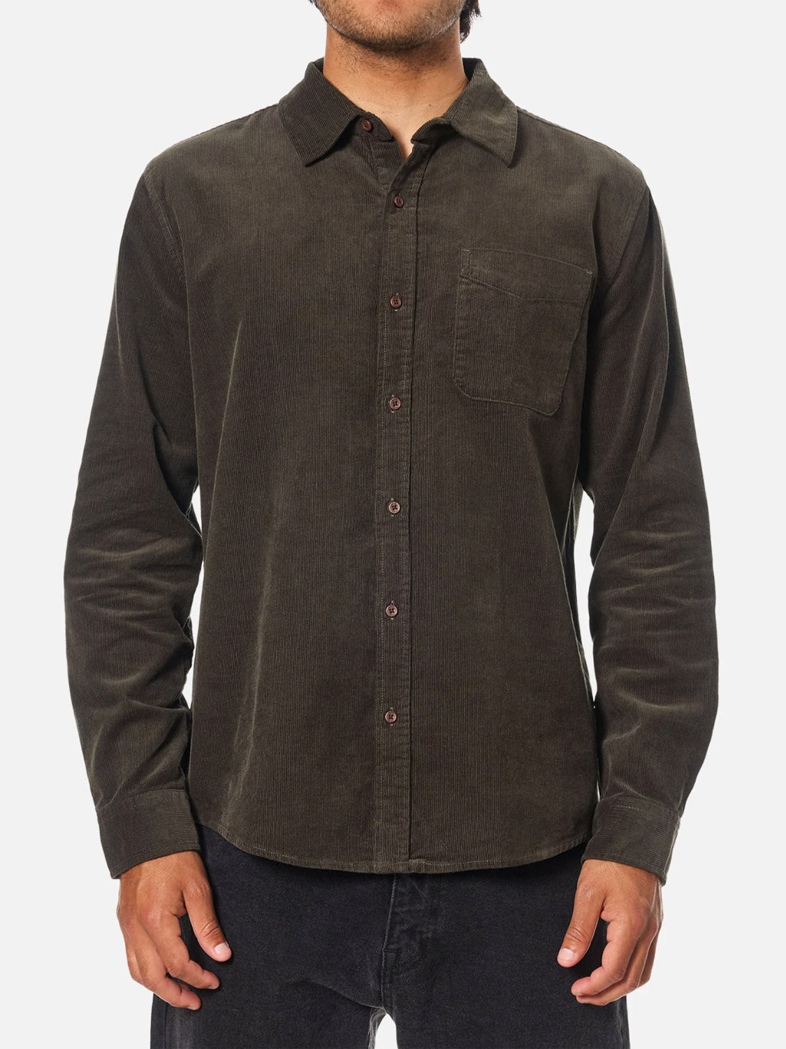 A person wears the Katin Granada Shirt, a dark brown cotton corduroy button-down with a chest pocket, standing against a plain white background.