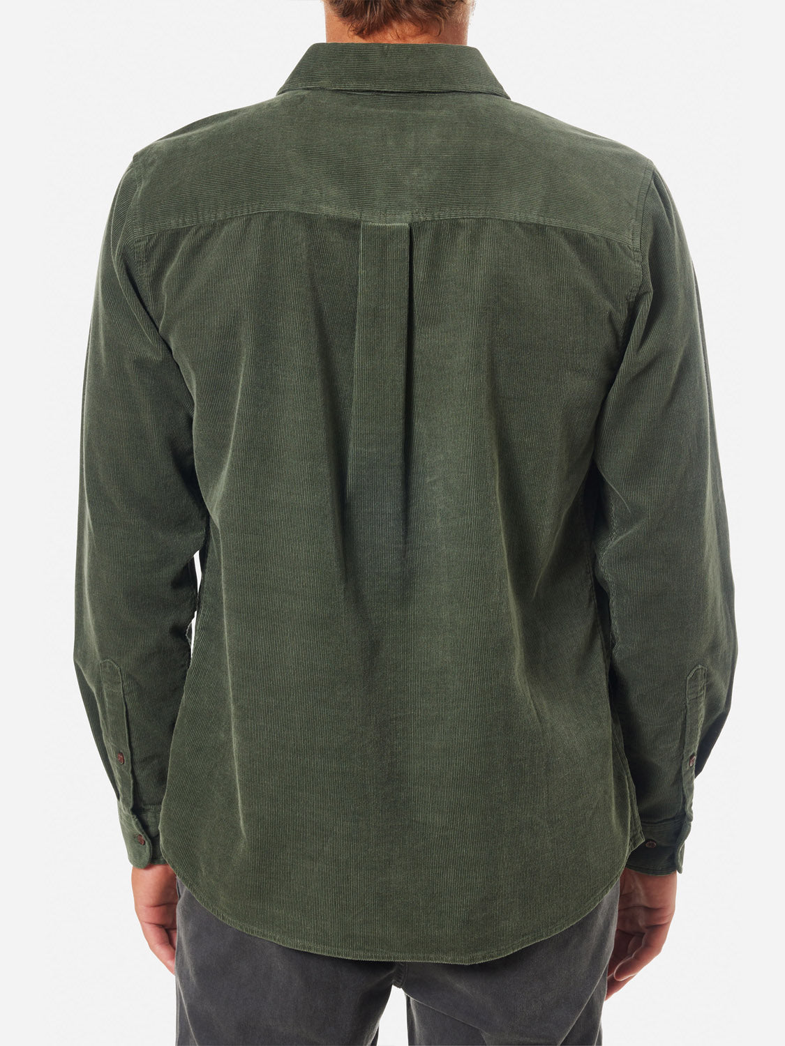 A person is seen from behind wearing a long-sleeved, Katin Granada Shirt in forest green cotton corduroy with a center back pleat, paired with dark gray pants. The outfit captures the fall collections essence against a plain white backdrop.