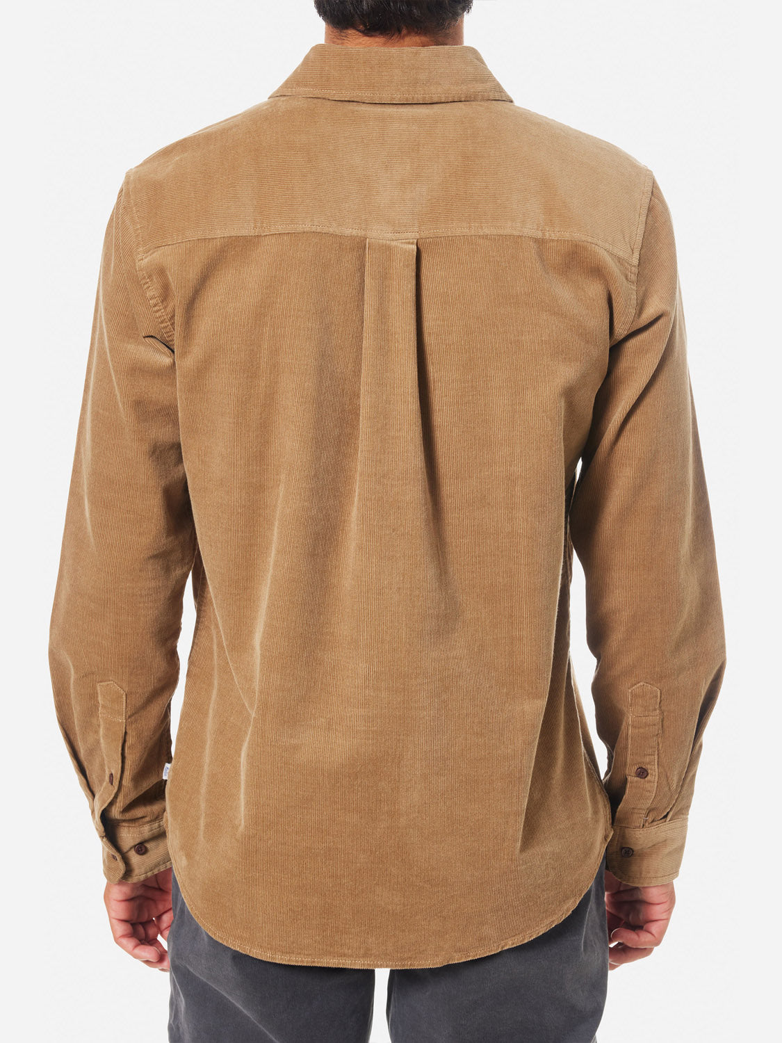 Rear view of a person wearing the Katin Granada Shirt from the fall collection, made with brown cotton corduroy. This long-sleeve shirt features a straight hem and back pleats, perfectly complemented by dark pants.