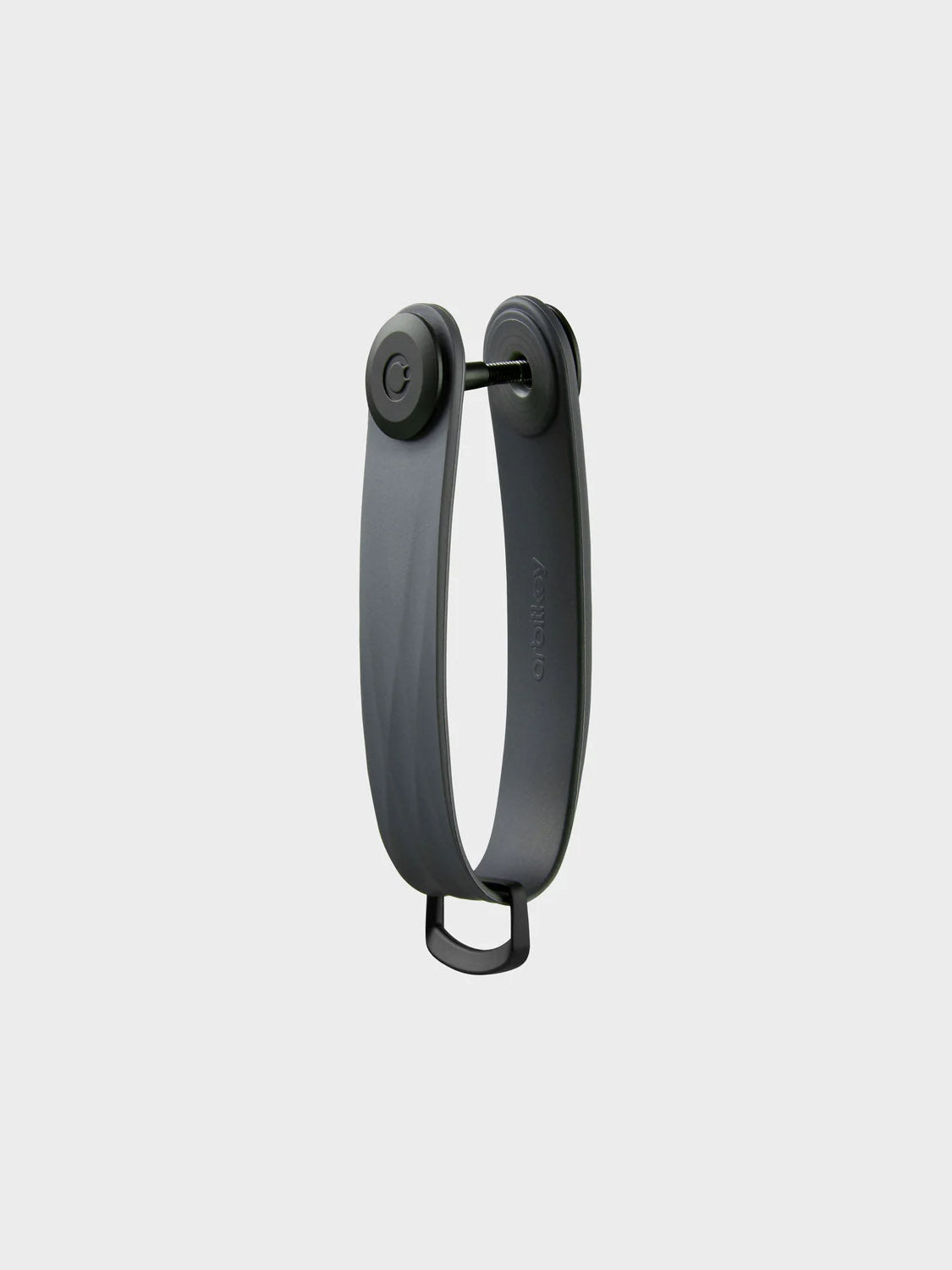 The Orbitkeys Key Organizer Rubber Active is a dark gray, flexible U-shaped key holder with a circular lock at the top and a small loop at the bottom, shown on a plain light gray background.