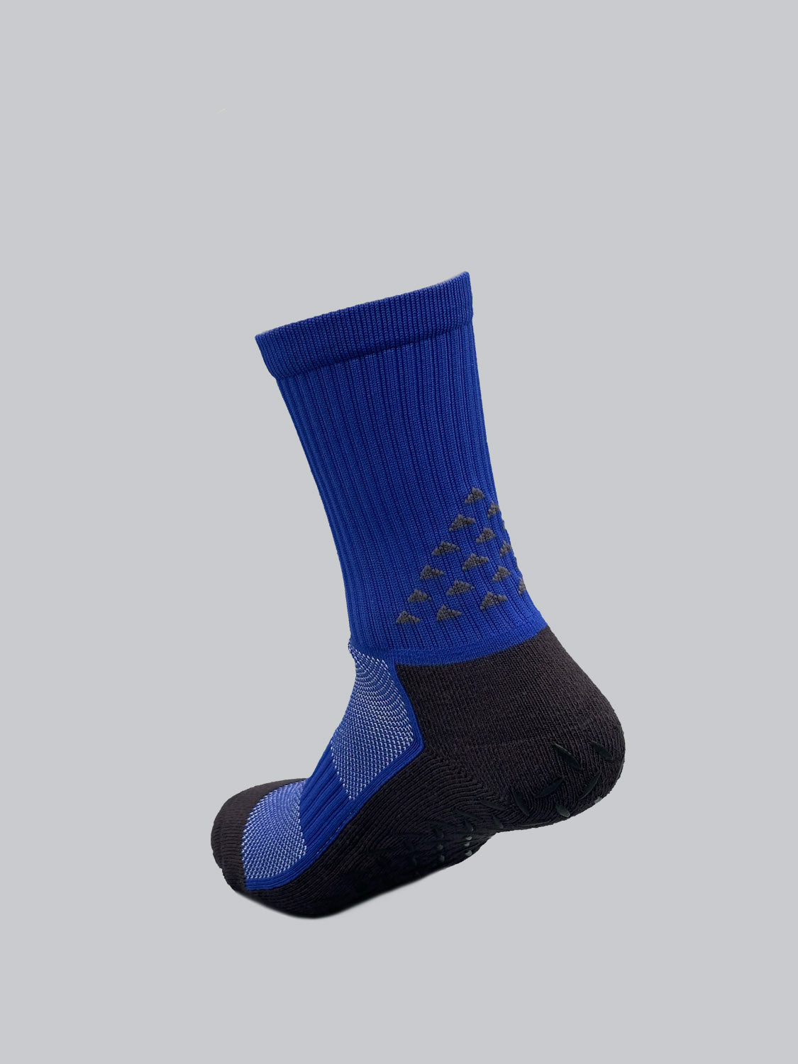 The Grip Sports Socks by ID Menswear are blue and black, featuring a geometric heel pattern and ribbed upper texture for performance and comfort. An anti-slip design enhances grip. They are displayed on a light gray background.
