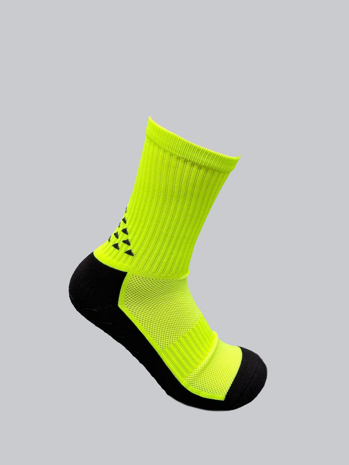 The Grip Sports Socks by ID Menswear are bright fluorescent yellow with a geometric pattern near the ankle, black heel and toe, and an anti-slip design for excellent grip; presented against a plain gray background.