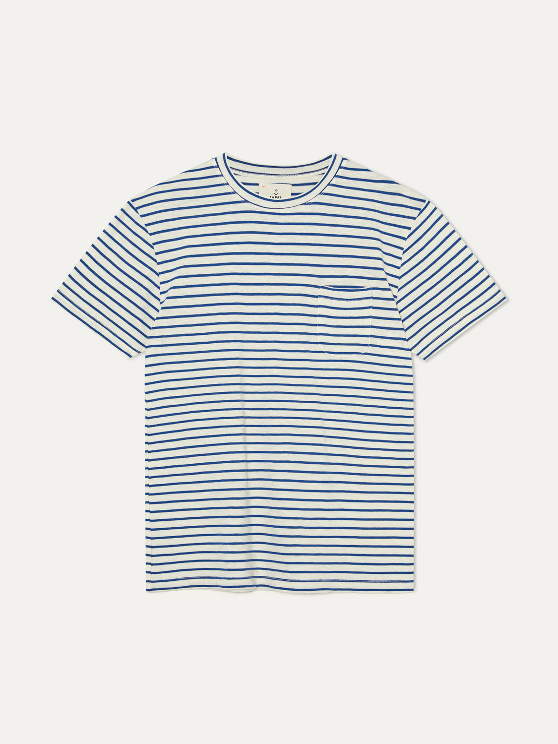 The La Paz Guerreiro Tee is a white T-shirt featuring lightweight cotton with horizontal navy blue stripes and a small chest pocket on the left side, styled against a plain white background. Ideal for summer wear.
