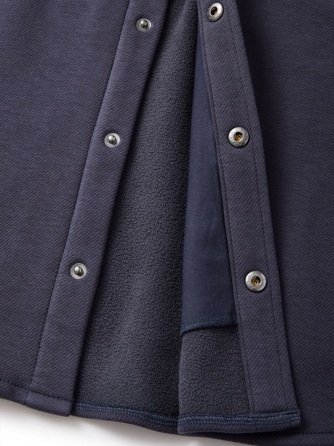 Close-up of the Katin Harold Fleece Jacket in navy blue with snap closure along the edge. The interior reveals darker blue fleece lining. This image showcases the texture and fastening details of this stylish poly-cotton blend garment by Katin.