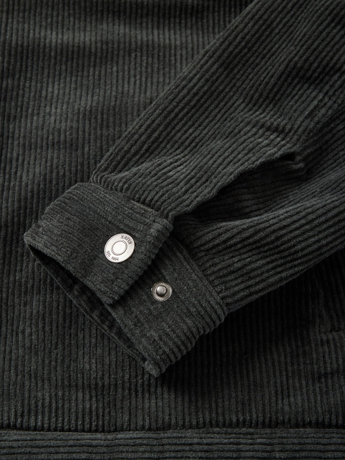 A close-up of the Katin Harris Corduroy Jacket sleeve cuff shows textured dark green ridges and a silver snap button detail.