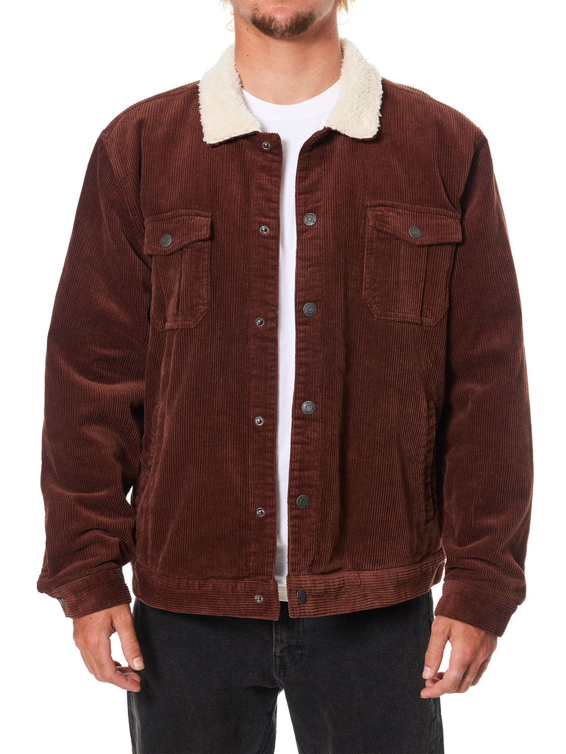 A person wears Katin's Harris Corduroy Jacket—brown with a white sherpa collar, buttoned front, and two chest pockets—paired with black pants, set against a plain white background.