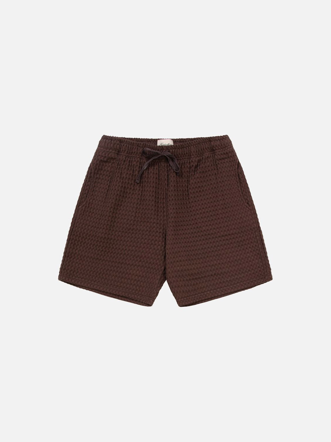 The Kuwalla Heavy Waffle Short is a pair of dark brown 100% cotton shorts with a textured finish, relaxed fit, elastic waistband, adjustable drawstring, and side pockets, shown against a plain white background.