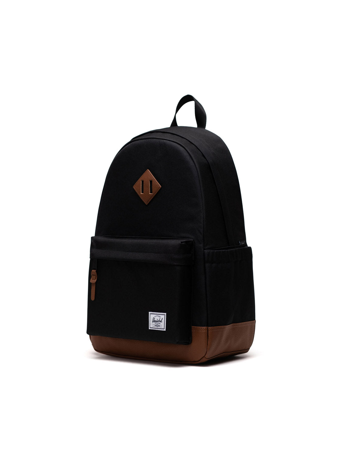 The Herschel Heritage Backpack in black features a brown leather bottom, front zipper pocket, side pockets, and a small white logo patch on the front pocket, photographed against a plain white background.