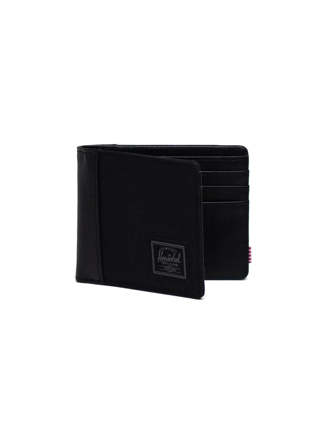 The Herschel Hank Wallet is a black bi-fold wallet featuring a small sewn-on Herschel logo patch on the front, RFID blocking technology, and multiple interior card slots, shown against a plain white background.