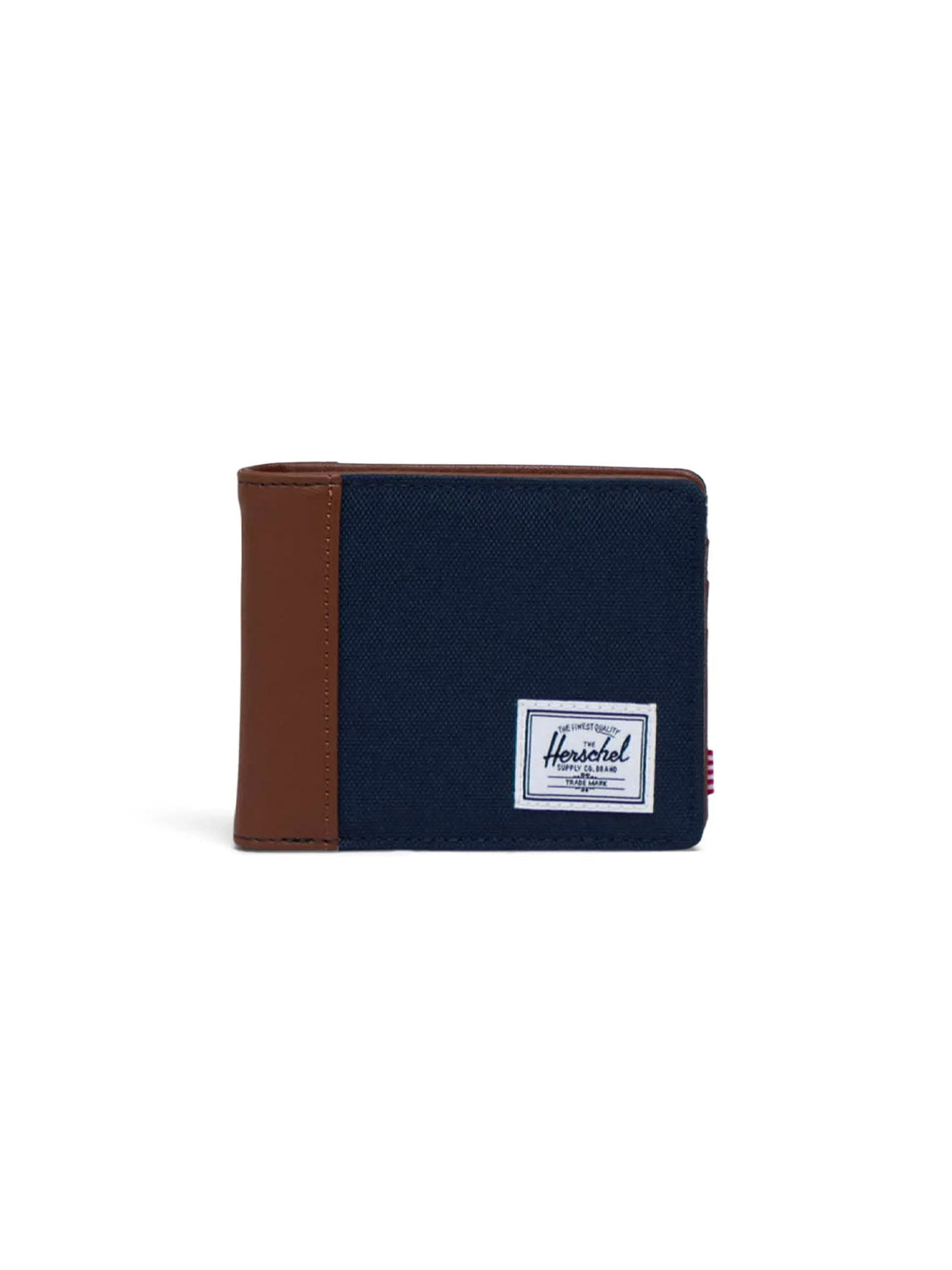 The Herschel Hank Wallet is a navy fabric bi-fold with brown leather trim on the left, featuring a white rectangular Herschel label on the front. It offers multiple card slots and stands upright against a white background.