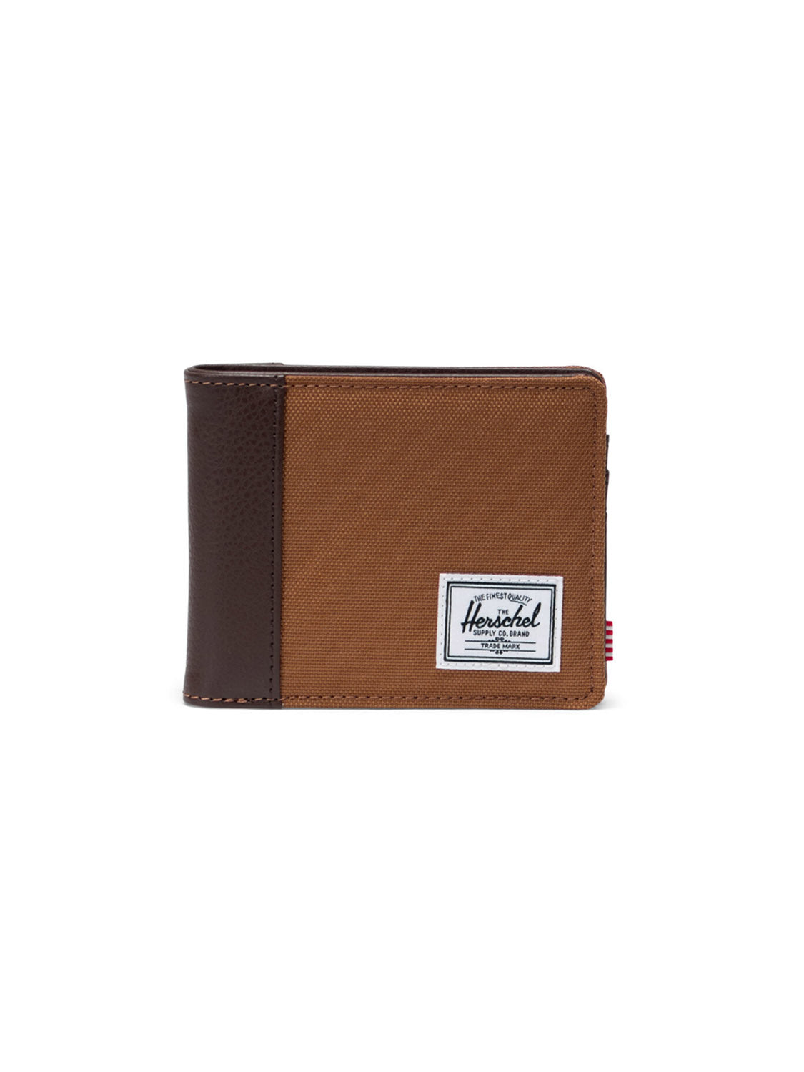 The Herschel Hank Wallet is a brown canvas bi-fold with a dark brown synthetic leather accent and a white rectangular Herschel label on the front. It stands closed and upright against a white background.