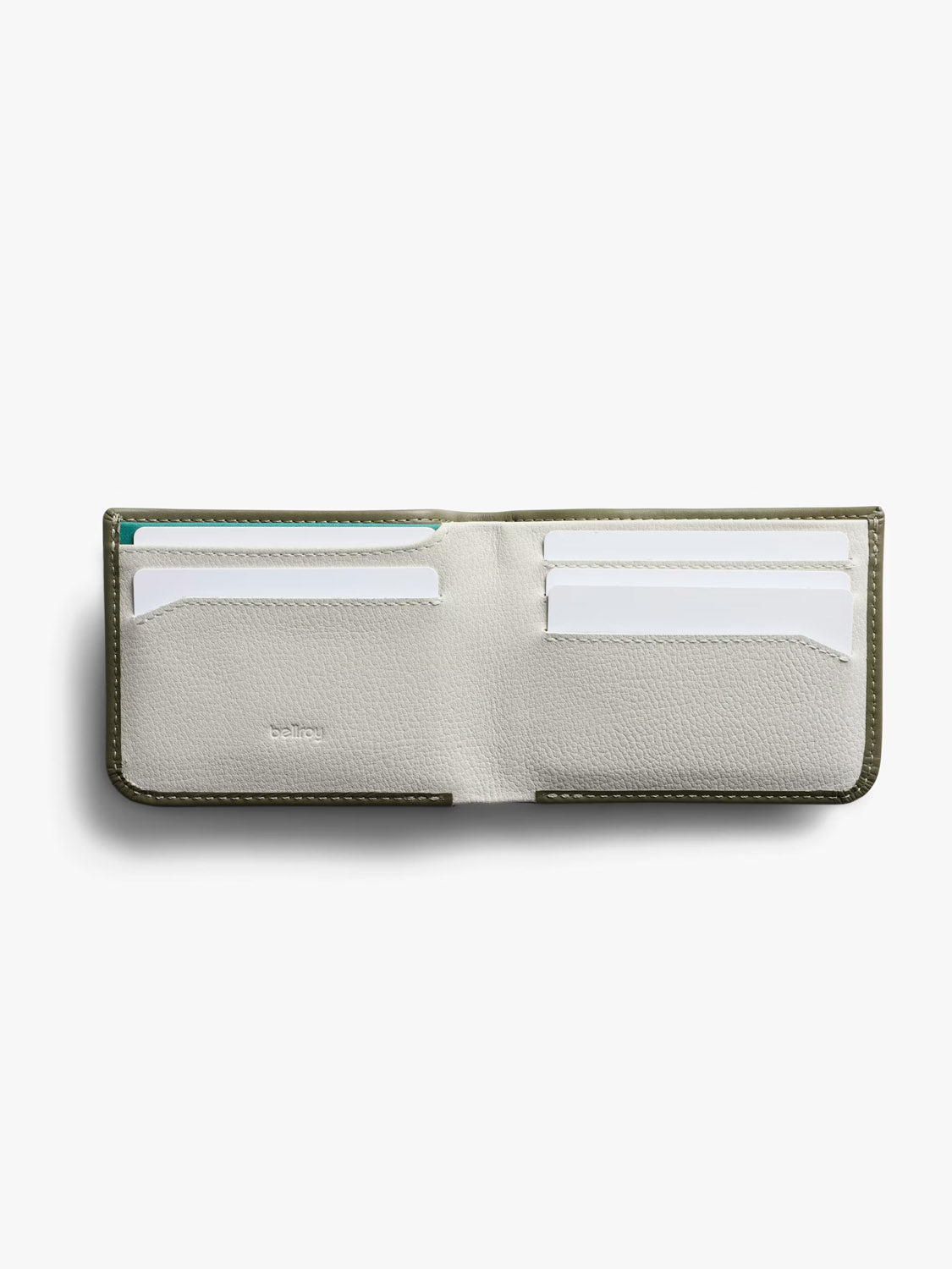 The Bellroy Hide and Seek Low Wallet is an open, slim wallet crafted from eco-tanned leather with a light gray interior, featuring four card slots—two on each side—with white and teal cards partially visible.