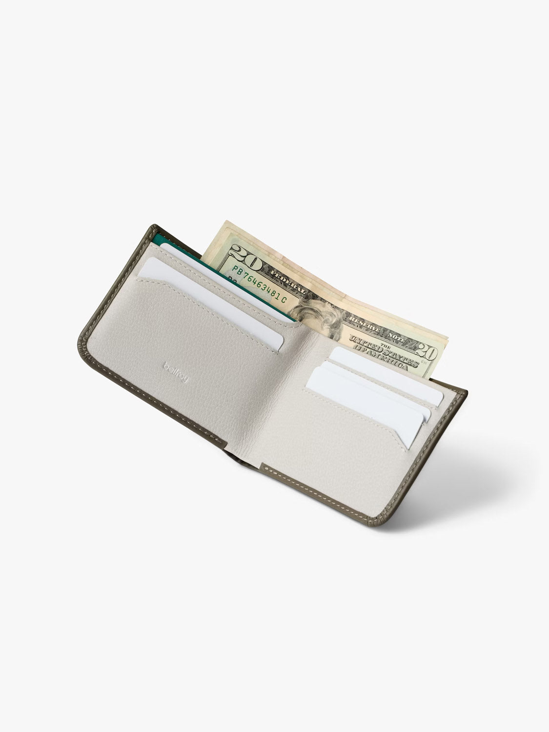 The Bellroy Hide and Seek Low Wallet in gray eco-tanned leather is open on a white surface, showing several cards in its slots and two twenty-dollar bills partially visible in the cash pocket.