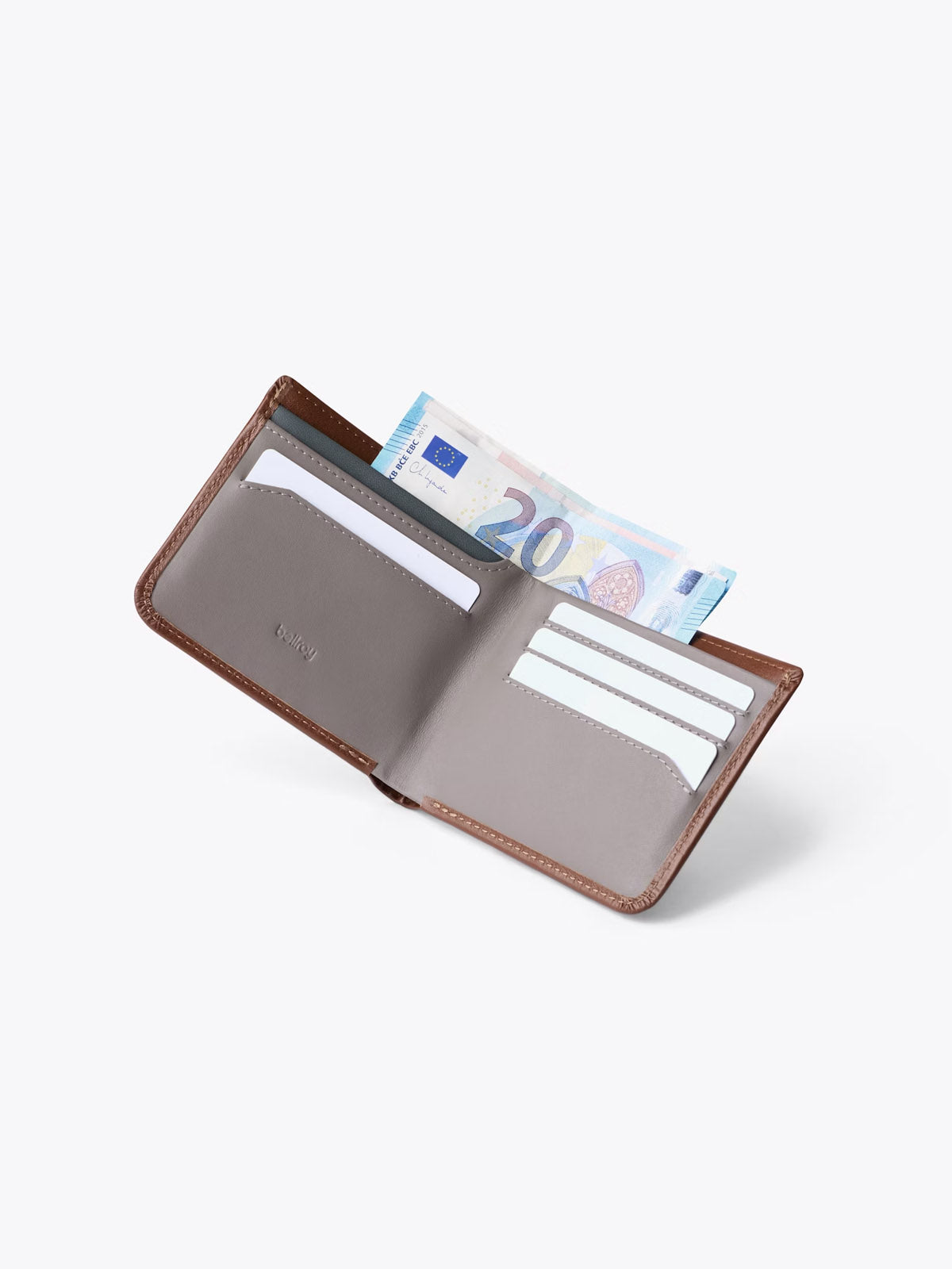 The Bellroy Hide and Seek Low Wallet, crafted from eco-tanned leather, lies open on a plain white background, displaying multiple card slots and a partially visible 20 euro note in the main bill compartment.