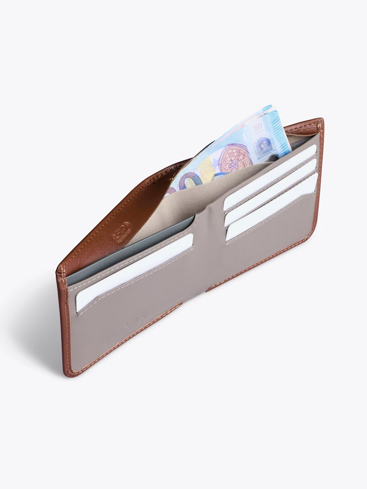 The Bellroy Hide and Seek Low Wallet in brown and gray leather is open, showing empty card slots and partially visible euro banknotes in the cash compartment.