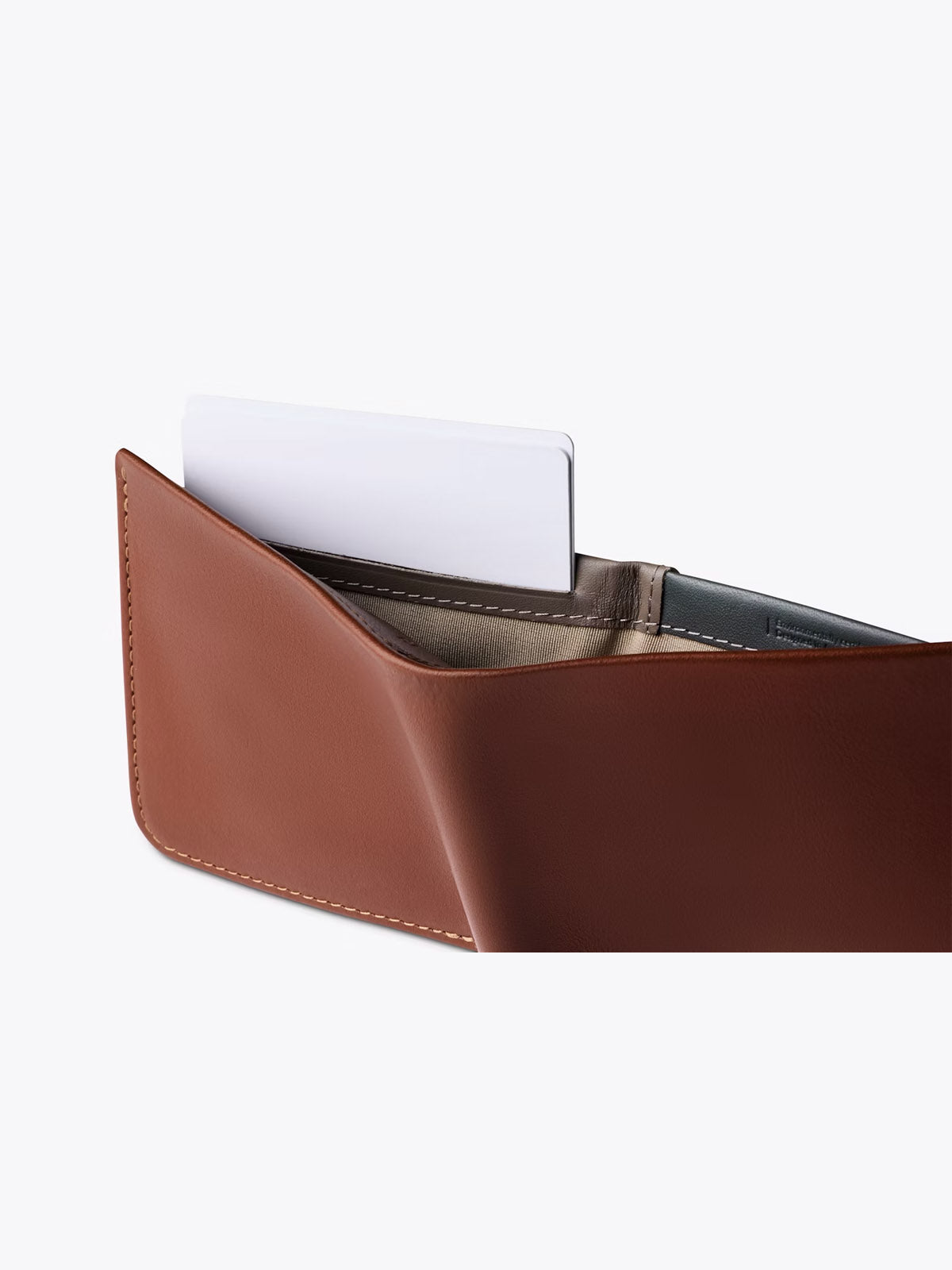 The Bellroy Hide and Seek Low Wallet in brown leather is shown partially open on a plain, light background, with a white card visible in one of its inner slots.