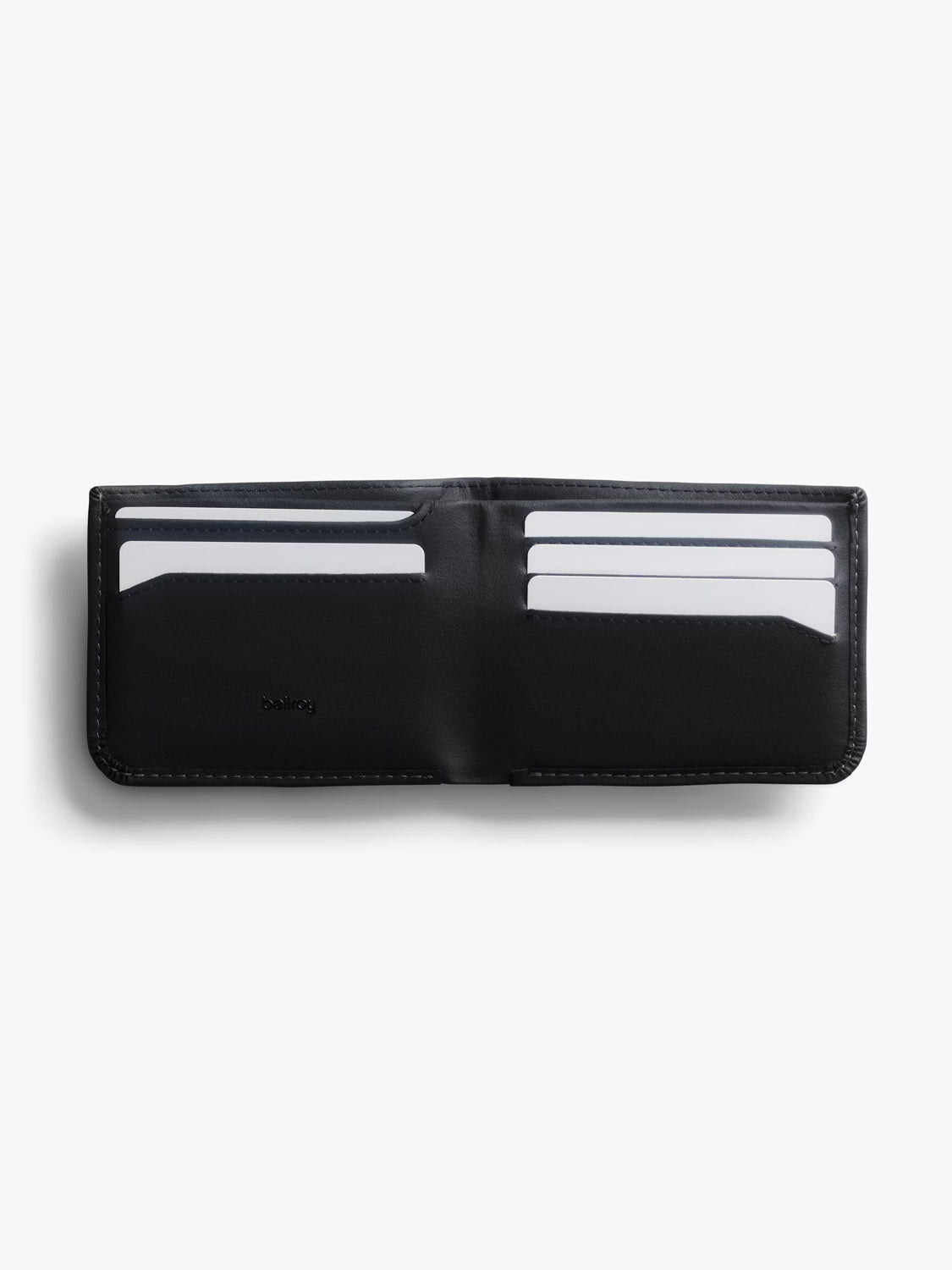 An open black Bellroy Hide & Seek Innovera™ Edition wallet with six visible card slots, each holding a white card, displayed on a white background. Includes built-in RFID protection for added security.