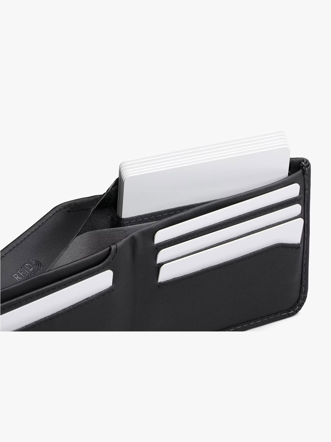 A Bellroy Hide & Seek Innovera™ Edition wallet in black leather is open, showing several white cards neatly organized in its slots, and features RFID protection for enhanced security.