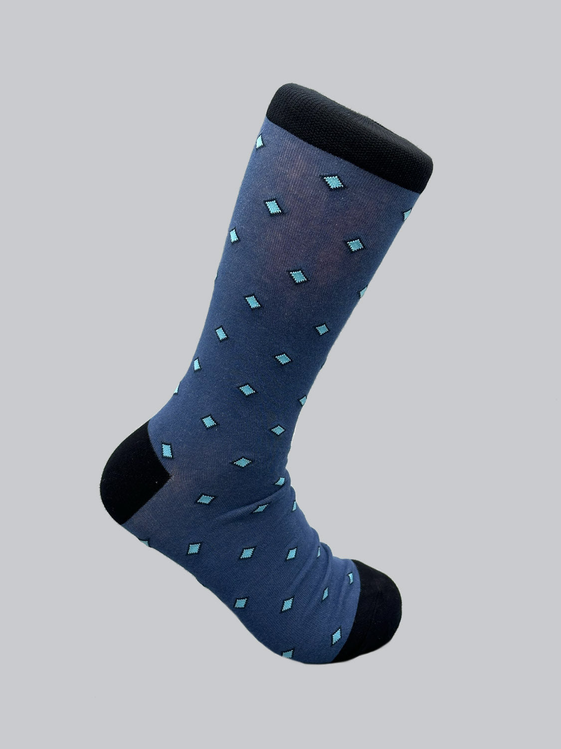 The ID Menswear Hishi Graphic Socks feature a blue sock with a delicate hishi pattern of light blue diamonds on a grey background, accented with black on the toe, heel, and cuff. Made from soft combed cotton, they offer a touch of Japanese elegance.