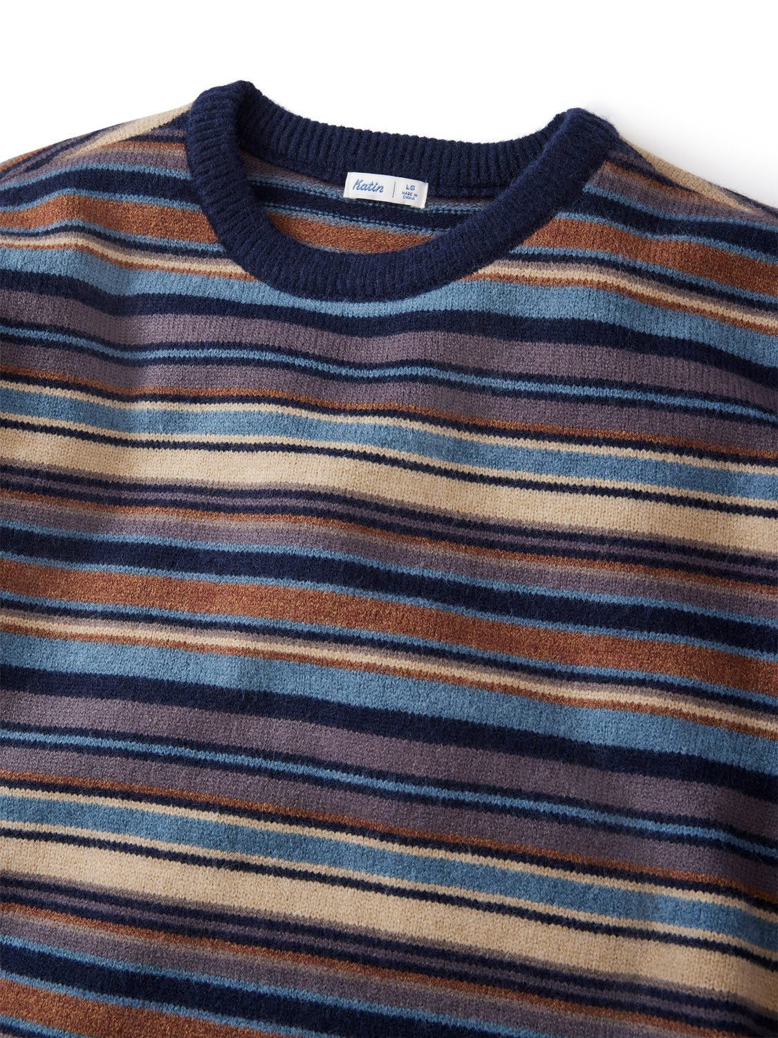 A close-up of the Katin Hitch Sweater highlights its custom blue, brown, beige, and cream stripes. This crewneck features a ribbed navy collar and ultra-soft blended yarn for a cozy, textured feel.