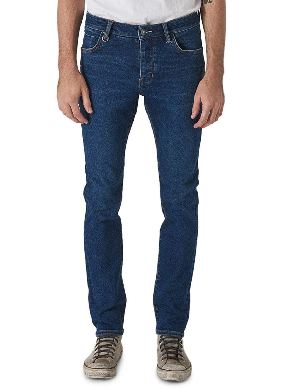 A person is shown from shoulders to feet against a plain white background, wearing a white T-shirt, gray sneakers, and Neuw Iggy Skinny Zero Utility Blue mid rise skinny fit jeans, standing with arms relaxed at their sides.