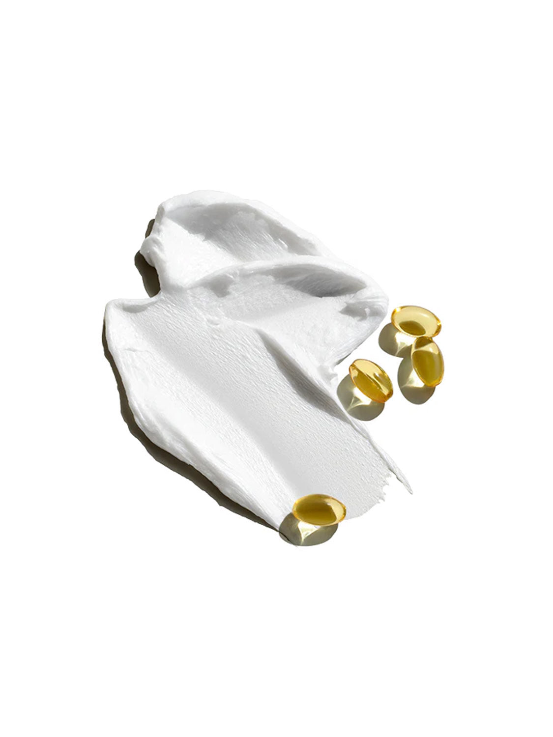 A smear of Jack Black Industrial Strength Hand Healer 3oz sits on a white surface, with five yellow oval gel capsules beside it—ideal for repairing cuticles and relieving dry hands.