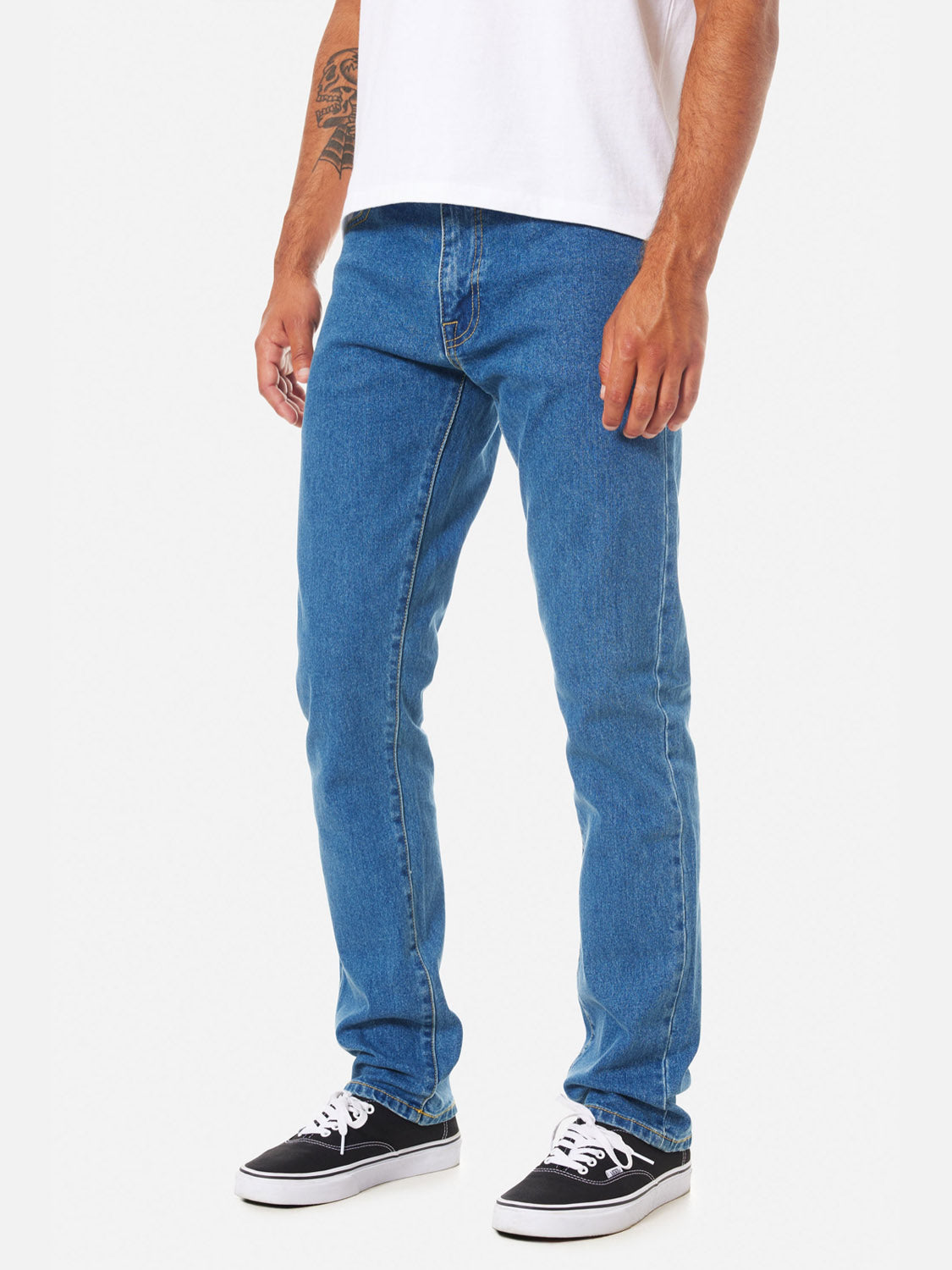 A person wearing Katin Jacob 71 Slim Straight Pants with 5-pocket styling, a white t-shirt, and black sneakers stands against a plain white background, showing a tattoo on their left forearm.