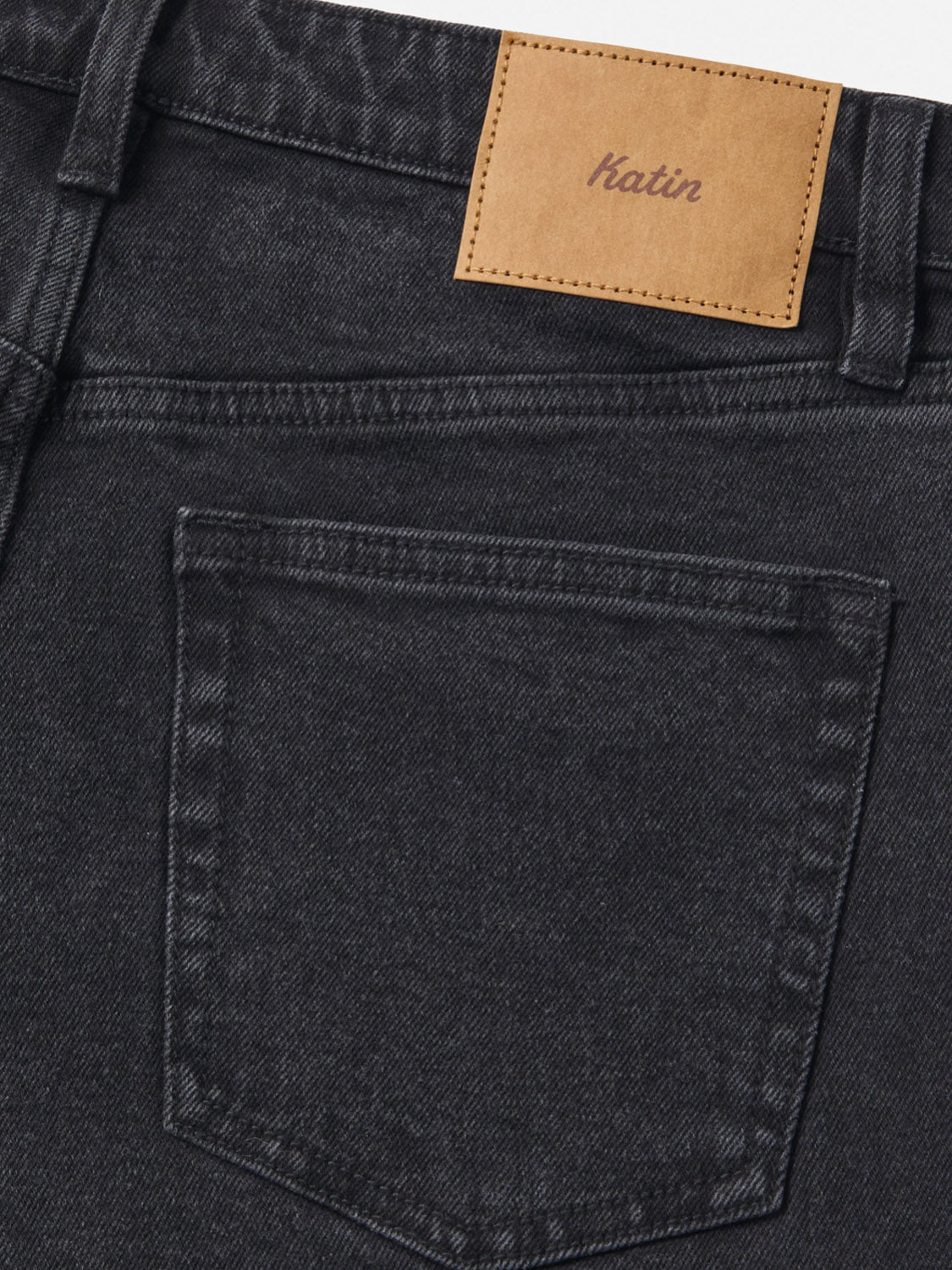 Close-up of the back pocket and waistband of black Jacob 71 Slim Straight Pants by Katin, showcasing classic 5-pocket design and a tan leather Katin patch stitched above the pocket.
