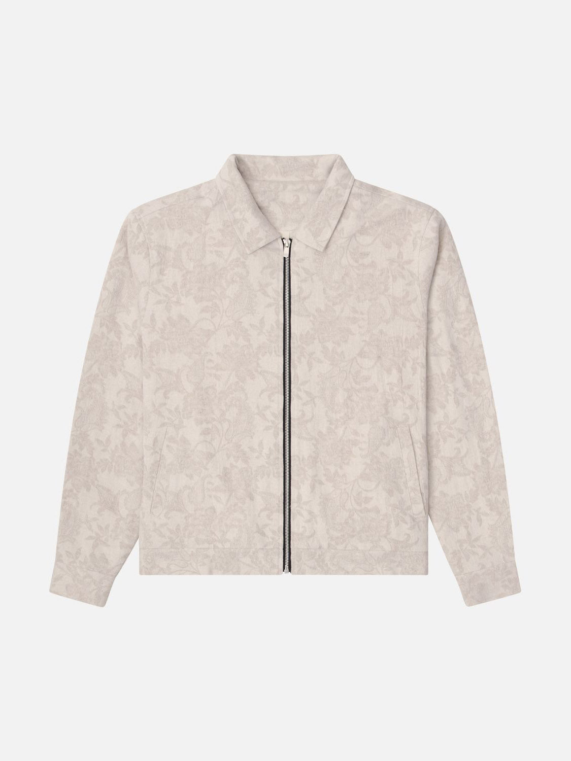 The Kuwalla Jacquard Linen Shacket by Kuwalla is a light beige linen shacket with a subtle floral pattern, featuring a full-length front zipper and classic collar. Its relaxed fit is ideal for transitional weather, offering style and comfort against any plain background.