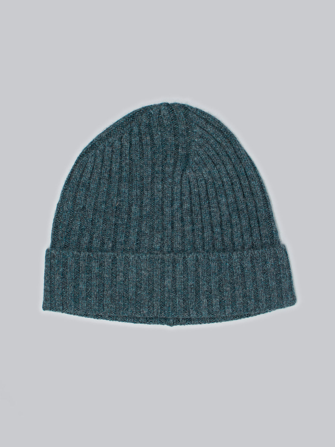 The Kailash Merino Wool Beanie by ID Menswear, in teal and featuring a ribbed texture and folded brim, is set against a light gray background. Made from warm and soft Merino wool, its perfect for outdoor adventures.