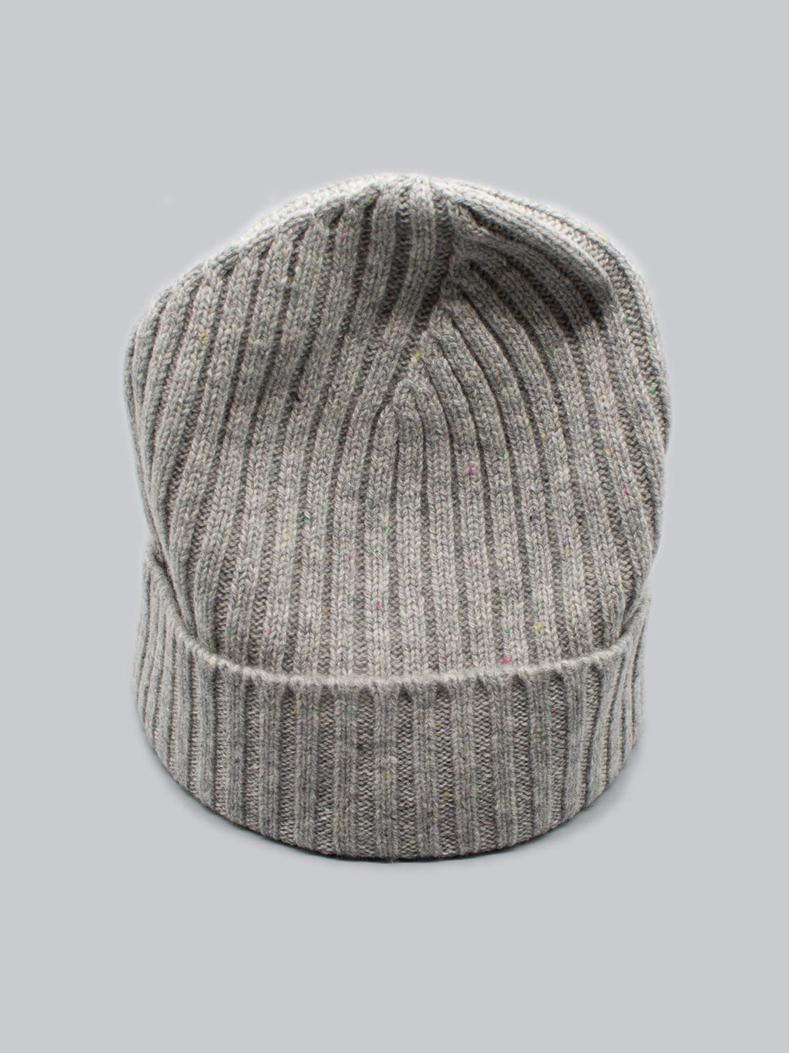 The Kailash Merino Wool Beanie by ID Menswear, in gray with a ribbed pattern, is shown on a plain light gray background. Ideal for outdoor adventures, it features a folded brim and slightly slouched top for added warmth and comfort.