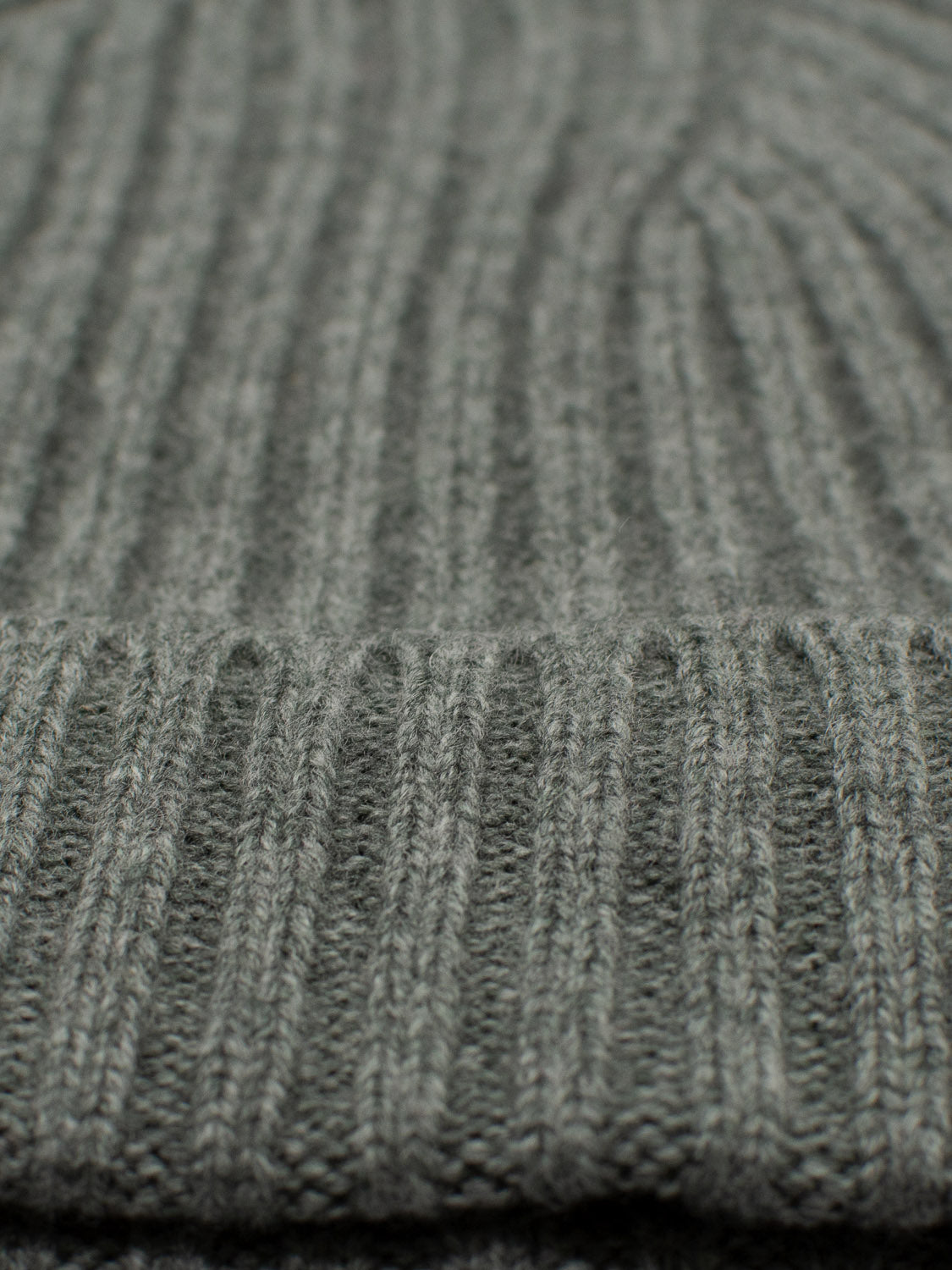 Close-up of the Kailash Merino Wool Beanie by ID Menswear, featuring textured gray knit with vertical ribbing. Crafted from Merino wool, it provides warmth and softness, perfect for cozy outdoor adventures.