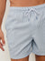 A person wearing Rails La Brea Swim Short in light blue and white vertical stripes, featuring polyester seersucker fabric and an adjustable drawstring, stands against a light background.