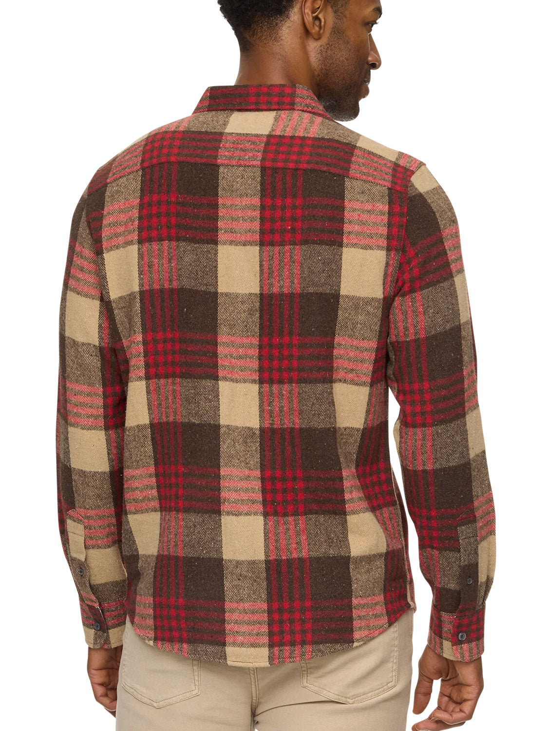 A man is seen from the back wearing the Flag and Anthem Lansing Herringbone Shirt, a tailored athletic-fit, long-sleeve button-up with a red, brown, and beige plaid pattern, paired with light-colored pants.