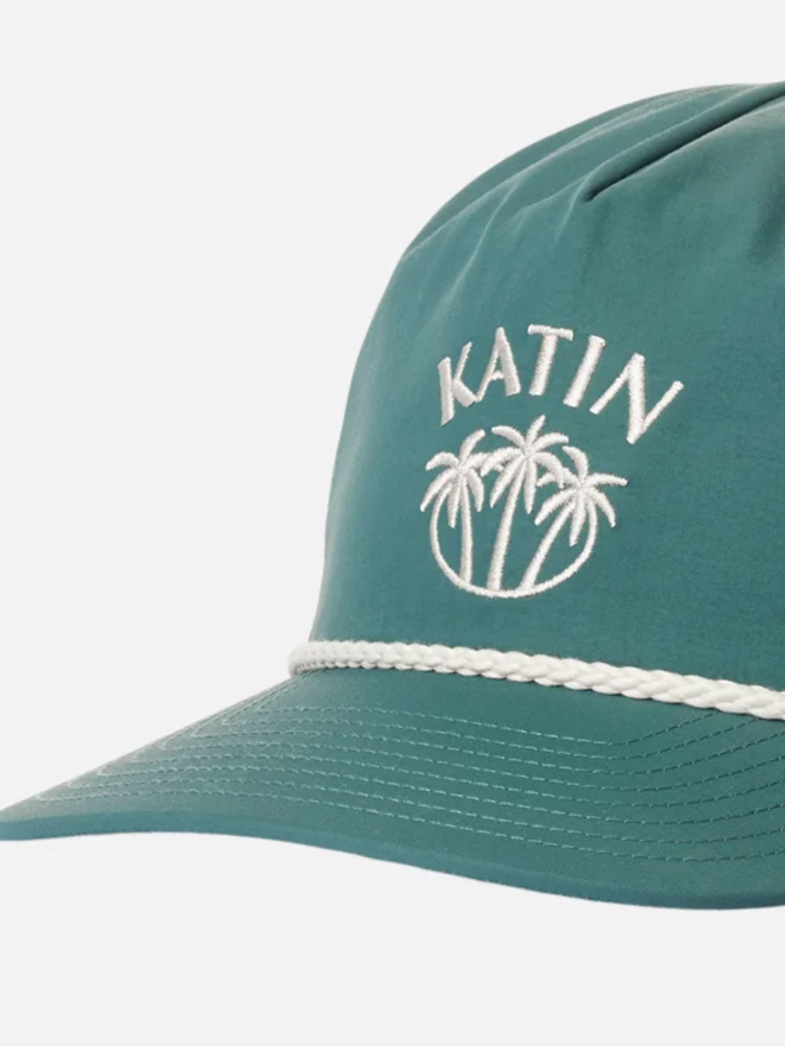 The Katin Largo Hat is made from teal recycled nylon with a white braided band, palm tree embroidery, and "KATIN" on the front. It features a snapback closure for easy adjustment.