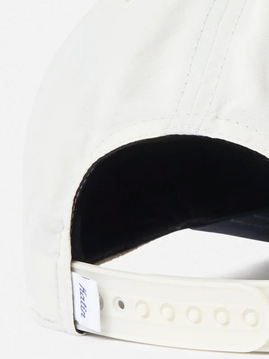 Close-up of the back of a white Largo Hat by Katin, featuring a 5-panel design, adjustable snapback closure, and a small white fabric tag with blue "hatsin" text.