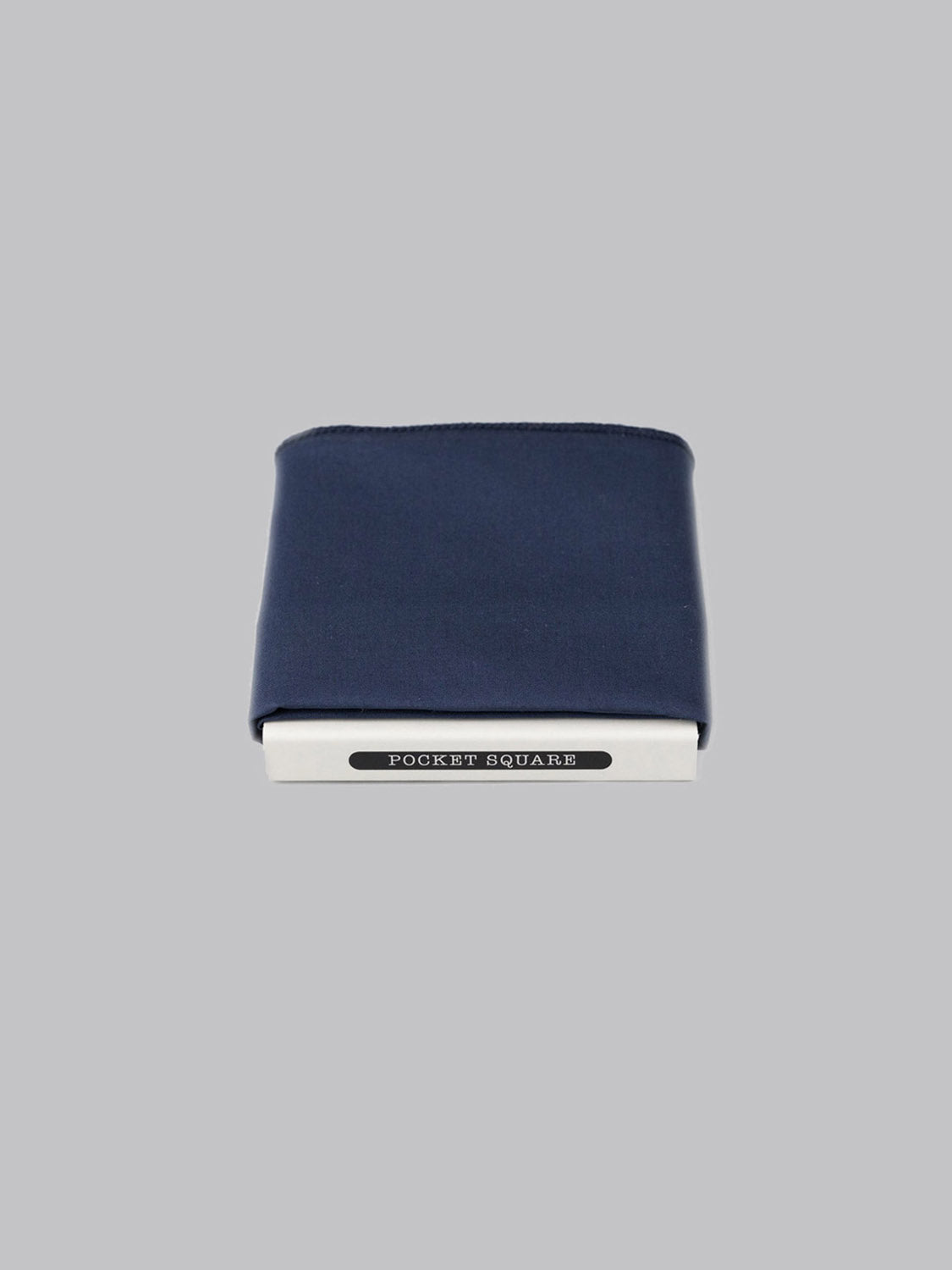 The Liberty™ Navy Pocket Square by ID Menswear, crafted from fine Tana Lawn cotton, is neatly folded atop a white box labeled POCKET SQUARE against a plain gray background.