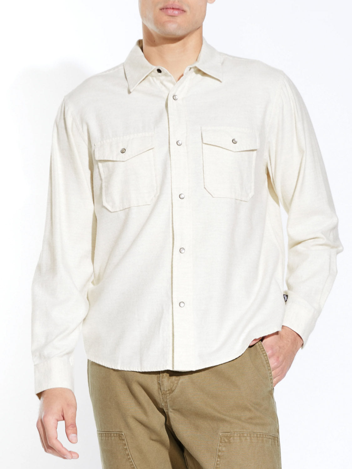 A person wears the Civil Society Linwood Relaxed Fit Western Shirt—an off-white, long-sleeve brushed flannel with faux pearl snaps and two chest pockets—paired with khaki pants against a plain white background.