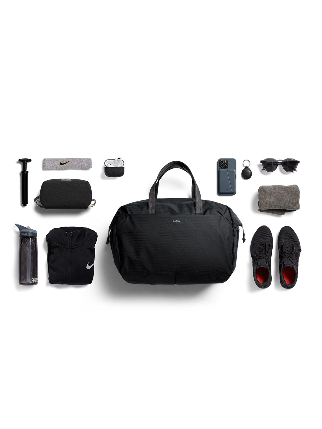 Top-down view of the Bellroy Lite Duffle Bag - 30L surrounded by gym essentials—water bottle, hoodie, shoes, socks, towel, portable speaker, earphones, smartwatch, smartphone, keychain, and a small air pump—neatly arranged on a white background.