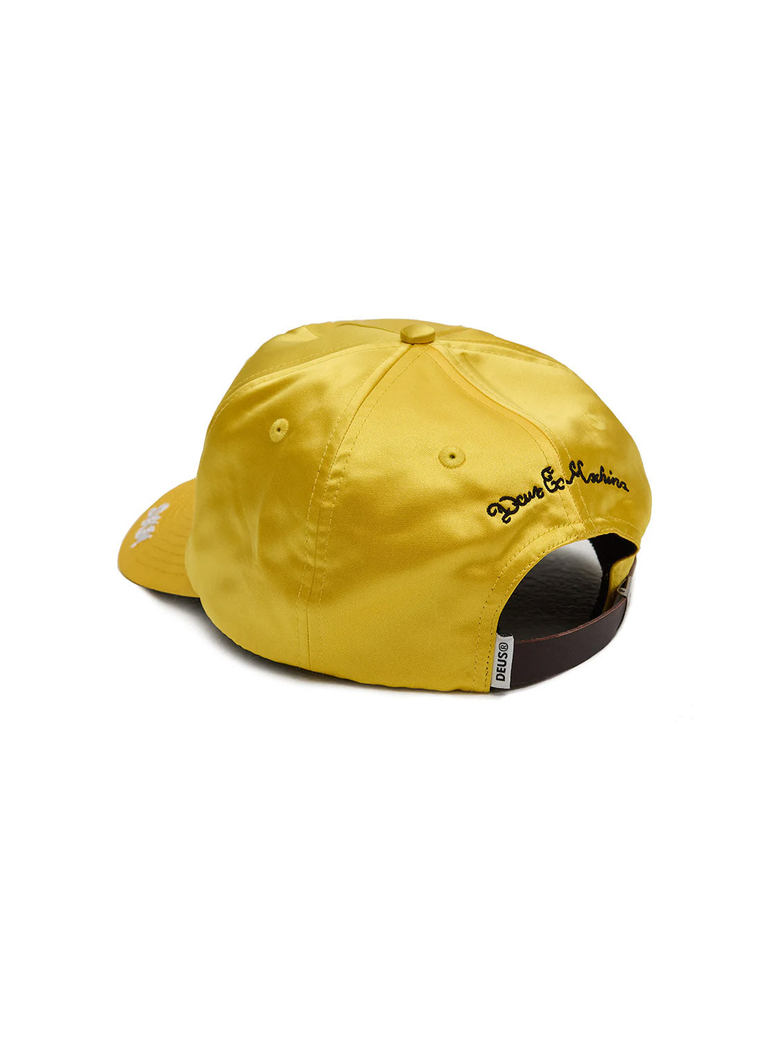 The Deus Lota Trucker is a yellow deep-fit hat with a curved brim, black chainstitch embroidery on the side, an adjustable brown strap, and smooth, shiny satin fabric.