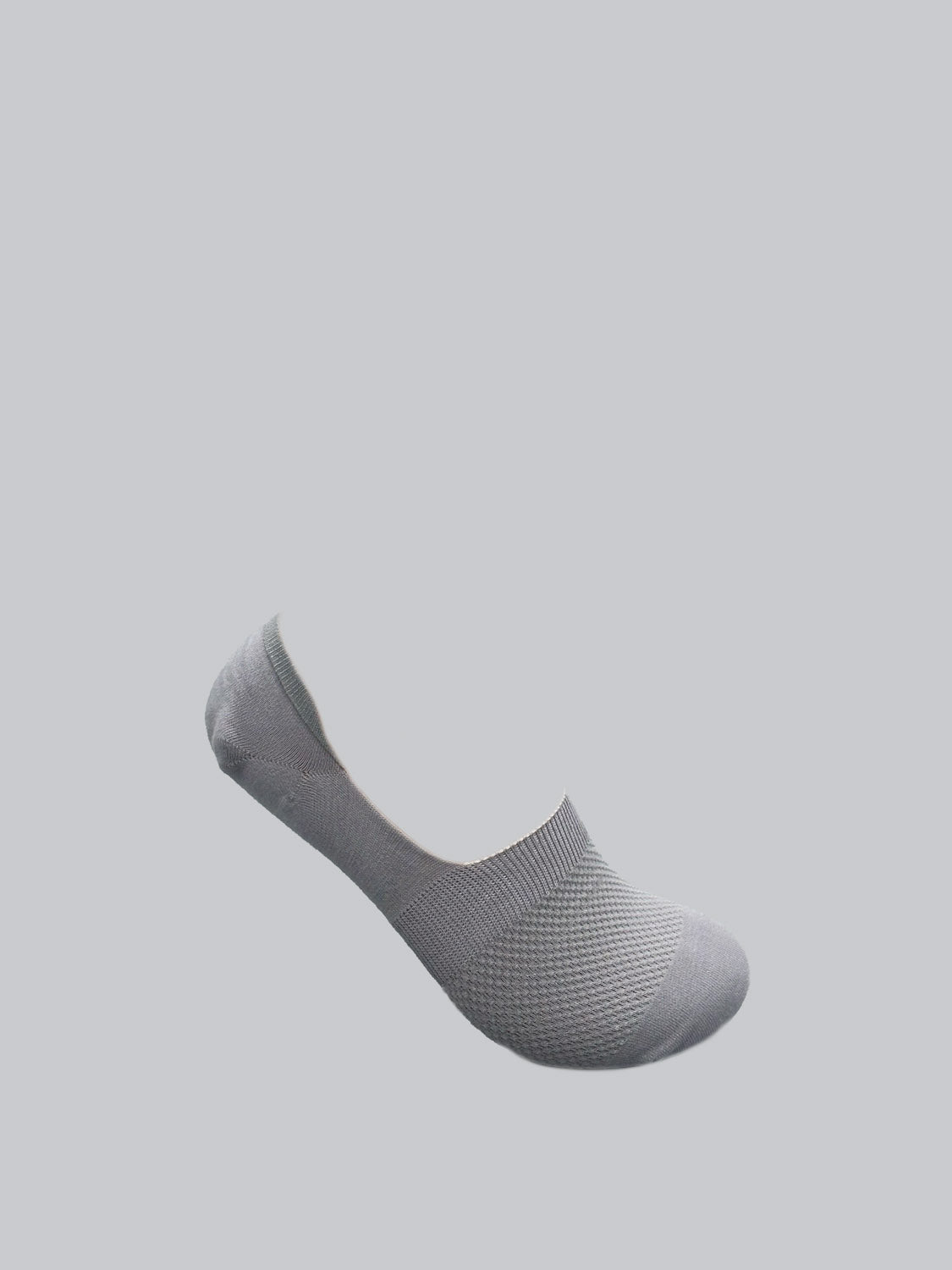 The gray ID Menswear M1 No Show Sock, made from soft combed cotton, elegantly contrasts with a light gray background and pairs seamlessly with low-cut shoes.
