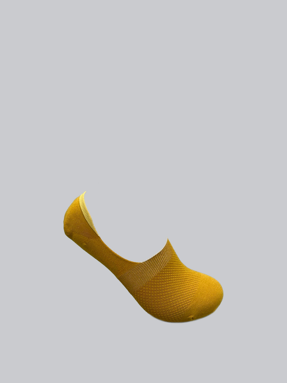 A single yellow M1 No Show Sock from ID Menswear, crafted with soft combed cotton, is displayed against a light gray background, elegantly arched to mimic its invisible fit in low-cut shoes.