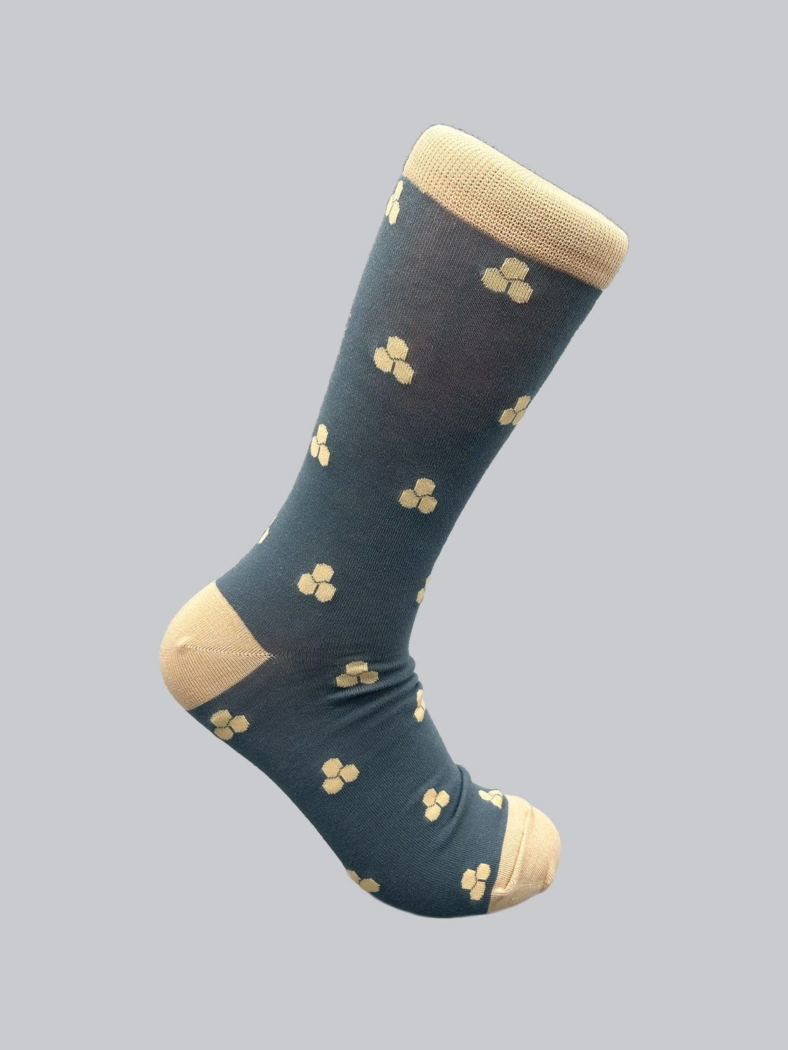 Experience the charm of Mae Graphic Socks by ID Menswear. These blue knee-highs feature a delightful array of small yellow flowers, crafted from premium combed cotton, with a solid yellow toe, heel, and top cuff on a plain gray background for ultimate comfort and style.